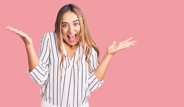 Young beautiful blonde woman wearing casual clothes celebrating victory with happy smile and winner expression with raised hands