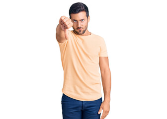 Fototapeta premium Young hispanic man wearing casual clothes looking unhappy and angry showing rejection and negative with thumbs down gesture. bad expression.