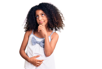 Fototapeta na wymiar African american child with curly hair wearing casual clothes serious face thinking about question with hand on chin, thoughtful about confusing idea