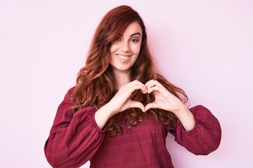 Young beautiful woman wearing casual winter sweater smiling in love showing heart symbol and shape with hands. romantic concept.