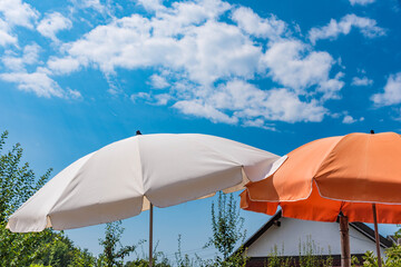 Sonnenschirme und blauer Himmel mit Wolken