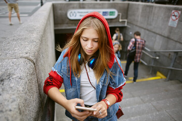 Young woman near underground entrance.
