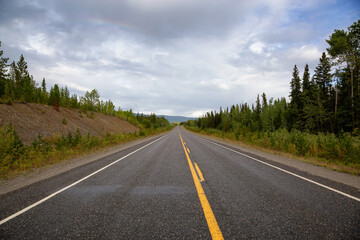 Beautiful View of a scenic road, Alaska Highway, in the Northern Rockies during a sunny and cloudy morning sunrise. Taken in British Columbia, Canada. Nature Background