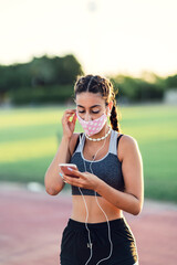 Naklejka premium Chica joven colocandose unos auriculares para hacer deporte