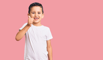 Little cute boy kid wearing casual white tshirt smiling happy and positive, thumb up doing excellent and approval sign