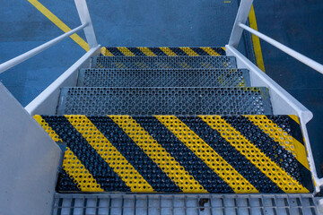 Fototapeta premium Ships stairs / stairway. First step off stairway painted in yellow black. Ships anti-slip stairs.