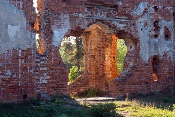 sunlight penetrates through openings of brick walls of ruined castle