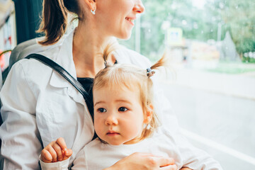 Caucasian kid rides in a tram with mom