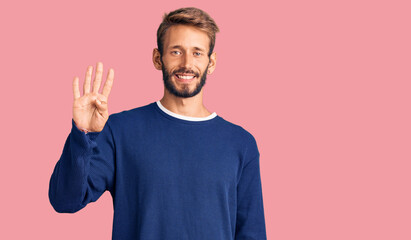 Handsome blond man with beard wearing casual sweater showing and pointing up with fingers number four while smiling confident and happy.