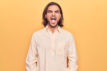 Young handsome man wearing business clothes sticking tongue out happy with funny expression. emotion concept.