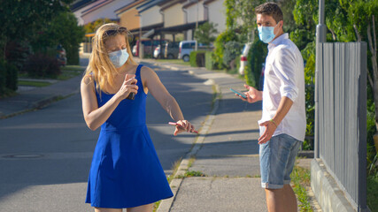 CLOSE UP: Woman sprays herself with sanitizing spray during covid-19 outbreak