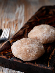 Semi prepared, ready to cook meat patties on a dark wooden cutting board, catalogue photo