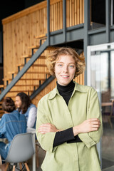 Young pretty blond female programmer in casualwear standing in front of camera