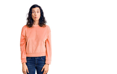 Obraz premium Young beautiful hispanic woman wearing casual clothes making fish face with lips, crazy and comical gesture. funny expression.