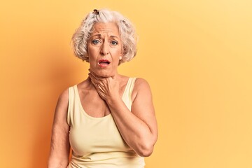 Senior grey-haired woman wearing casual clothes touching painful neck, sore throat for flu, clod and infection