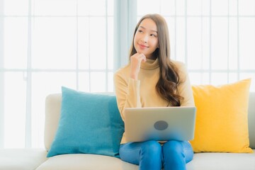 Portrait beautiful young asian woman use computer laptop on sofa decoration interior