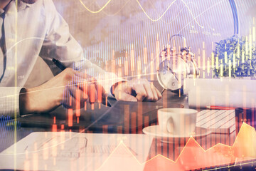 Double exposure of man's hands holding and using a phone and financial graph drawing. Analysis concept.