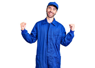 Young hispanic man wearing painter uniform screaming proud, celebrating victory and success very excited with raised arms
