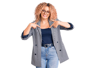 Young blonde woman with curly hair wearing business jacket and glasses looking confident with smile...