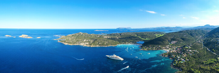 Obraz premium View from above, stunning panoramic view of the Grande Pevero beach with boats and luxury yachts sailing on a turquoise, clear water. Sardinia, Italy.