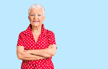 Senior beautiful woman with blue eyes and grey hair wearing a red summer dress happy face smiling...