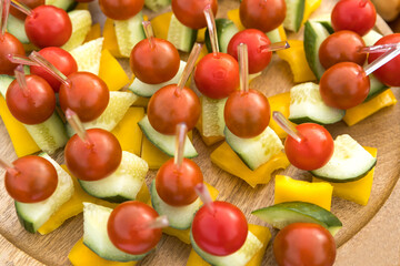 Canapes on a skewer of tomatoes, cucumbers, bell peppers, herbs