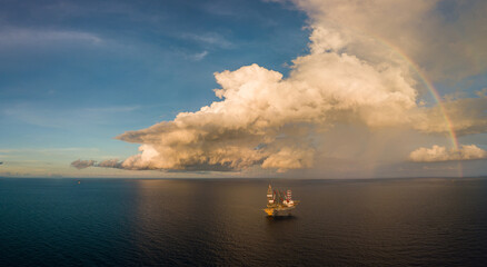 Naklejka na ściany i meble Aerial panorama view from a drone of an offshore jack up rig with beautiful sky and rainbow at the offshore location