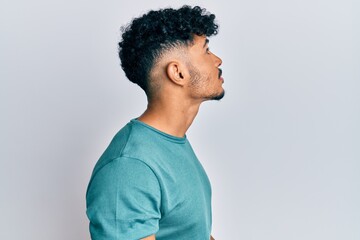 Young arab handsome man wearing casual clothes looking to side, relax profile pose with natural...