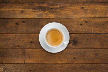 High angle view of coffee in white cup with saucer on old wooden background, close up