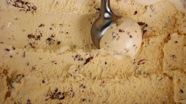 Ice cream Chocolate Chip scooped out from container with a spoon, Closeup Food concept.
