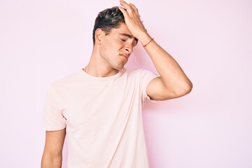 Young handsome man wearing casual clothes surprised with hand on head for mistake, remember error. forgot, bad memory concept.