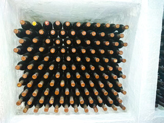 Dusty wine bottles on shelfs in cellars of winery