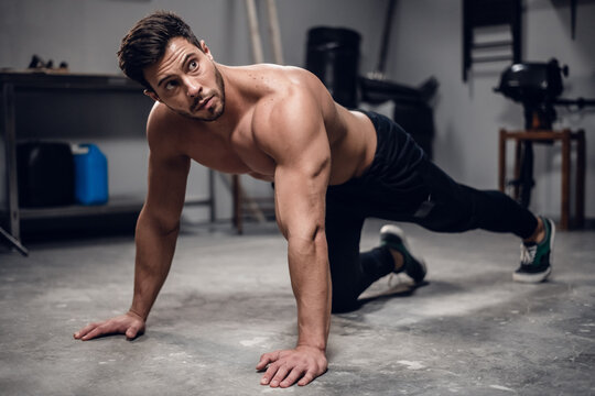 a muscular sportsman does push-UPS from the floor in the gym