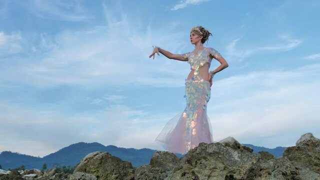 Magical fairy posing on a rocky sea shore
