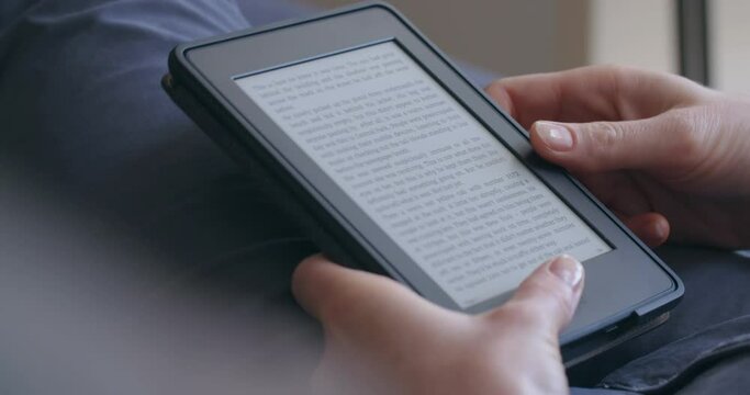 A woman reading an e-book on a device with an electronic ink display.