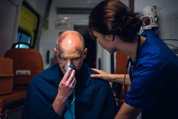 A medical worker talking to an injured man, trying to comfort him.