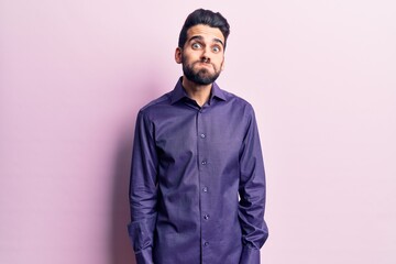 Obraz premium Young handsome man with beard wearing casual shirt puffing cheeks with funny face. mouth inflated with air, crazy expression.
