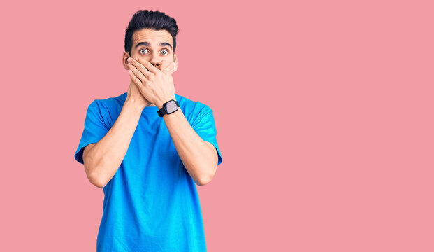 Young handsome man with beard wearing casual t-shirt shocked covering mouth with hands for mistake. secret concept.