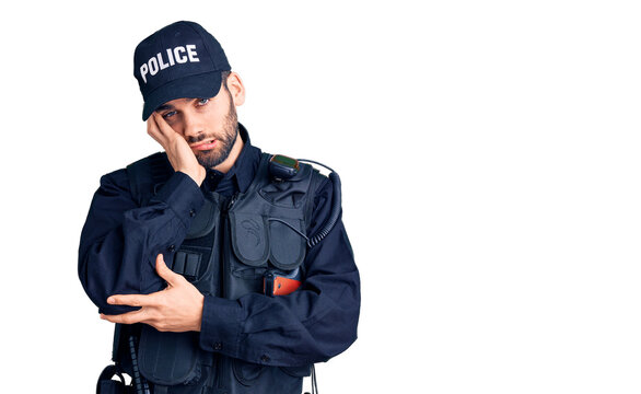 Young handsome man with beard wearing police uniform thinking looking tired and bored with depression problems with crossed arms.