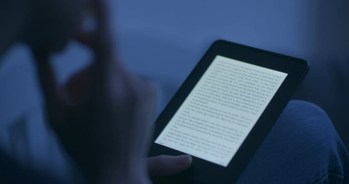 A woman reading an e-book in the evening or by night.