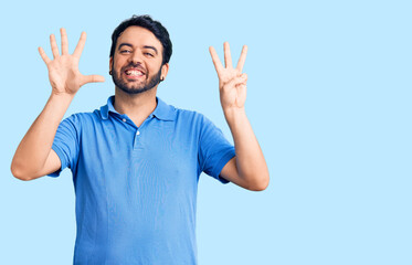 Young hispanic man wearing casual clothes showing and pointing up with fingers number eight while smiling confident and happy.