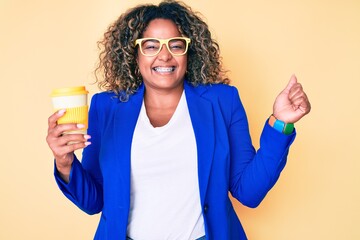 Young african american plus size woman wearing glasses holding take away cup of coffee screaming proud, celebrating victory and success very excited with raised arm