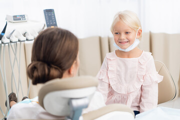 Obraz premium Beautiful brunette female doctor with her little patient.