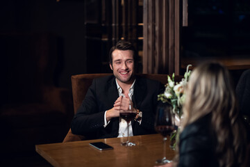a couple in love celebrates their anniversary in a restaurant at a table with a bouquet of flowers.