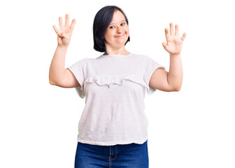 Brunette woman with down syndrome wearing casual white tshirt showing and pointing up with fingers number nine while smiling confident and happy.