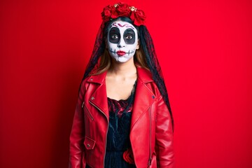 Woman wearing day of the dead costume over red puffing cheeks with funny face. mouth inflated with air, crazy expression.