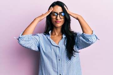 Beautiful hispanic woman wearing casual clothes and glasses with hand on head, headache because stress. suffering migraine.