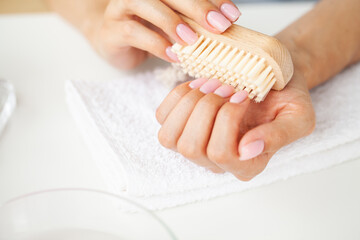Close up of woman using nail brush on fingernails
