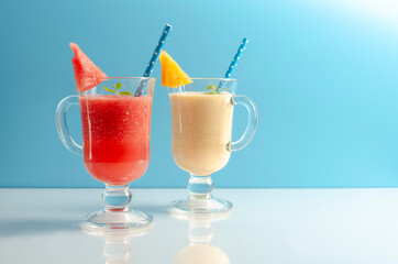 Watermelon and melon smoothies in a glass on colored
