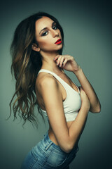 Naklejka premium fashion and people concept: woman wearing jeans posing over grey background